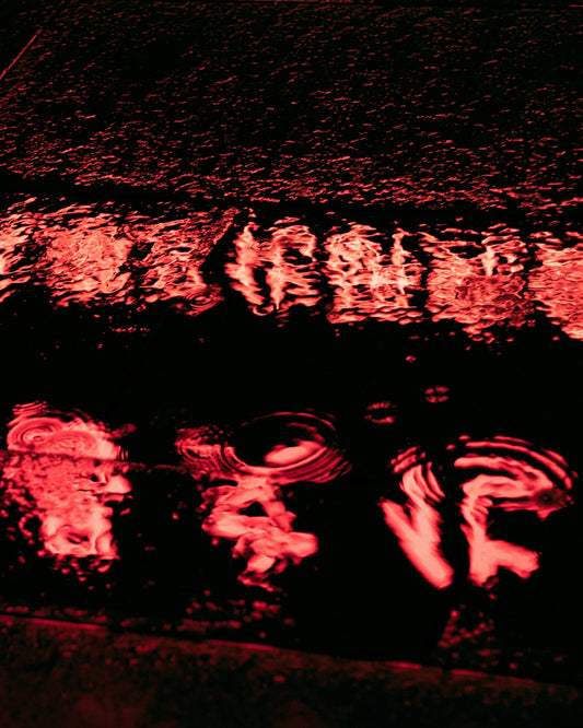 a street sign that is reflecting in a puddle of water
