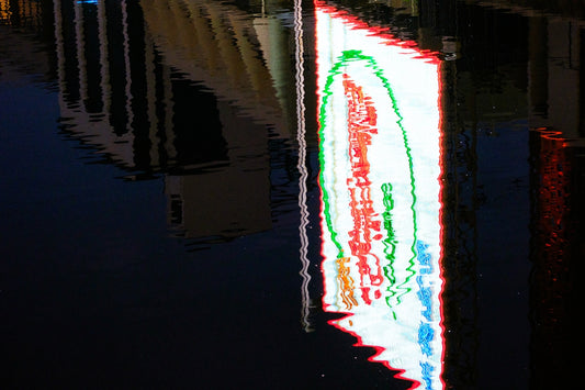 a lighted sign on a sidewalk