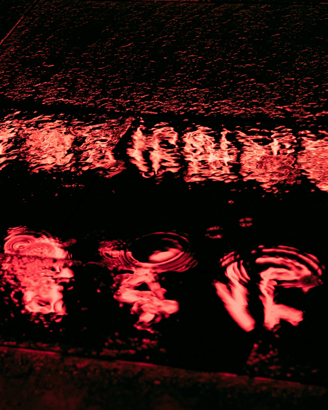 a street sign that is reflecting in a puddle of water