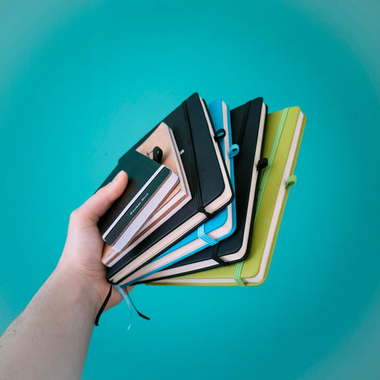 person holding green and black books
