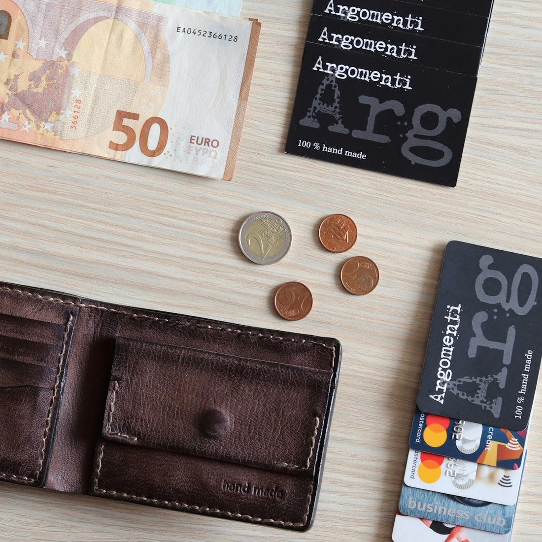 50 euro and coins on white wooden table