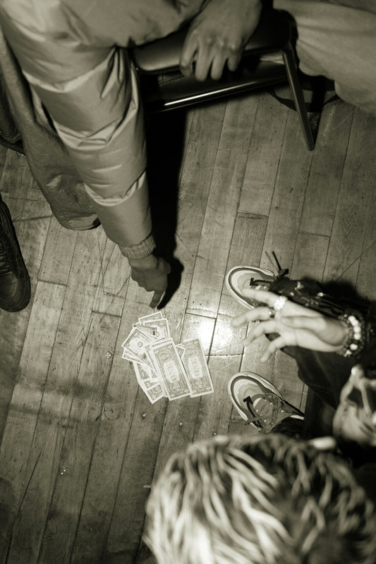 person in white pants and black leather boots standing on brown wooden floor
