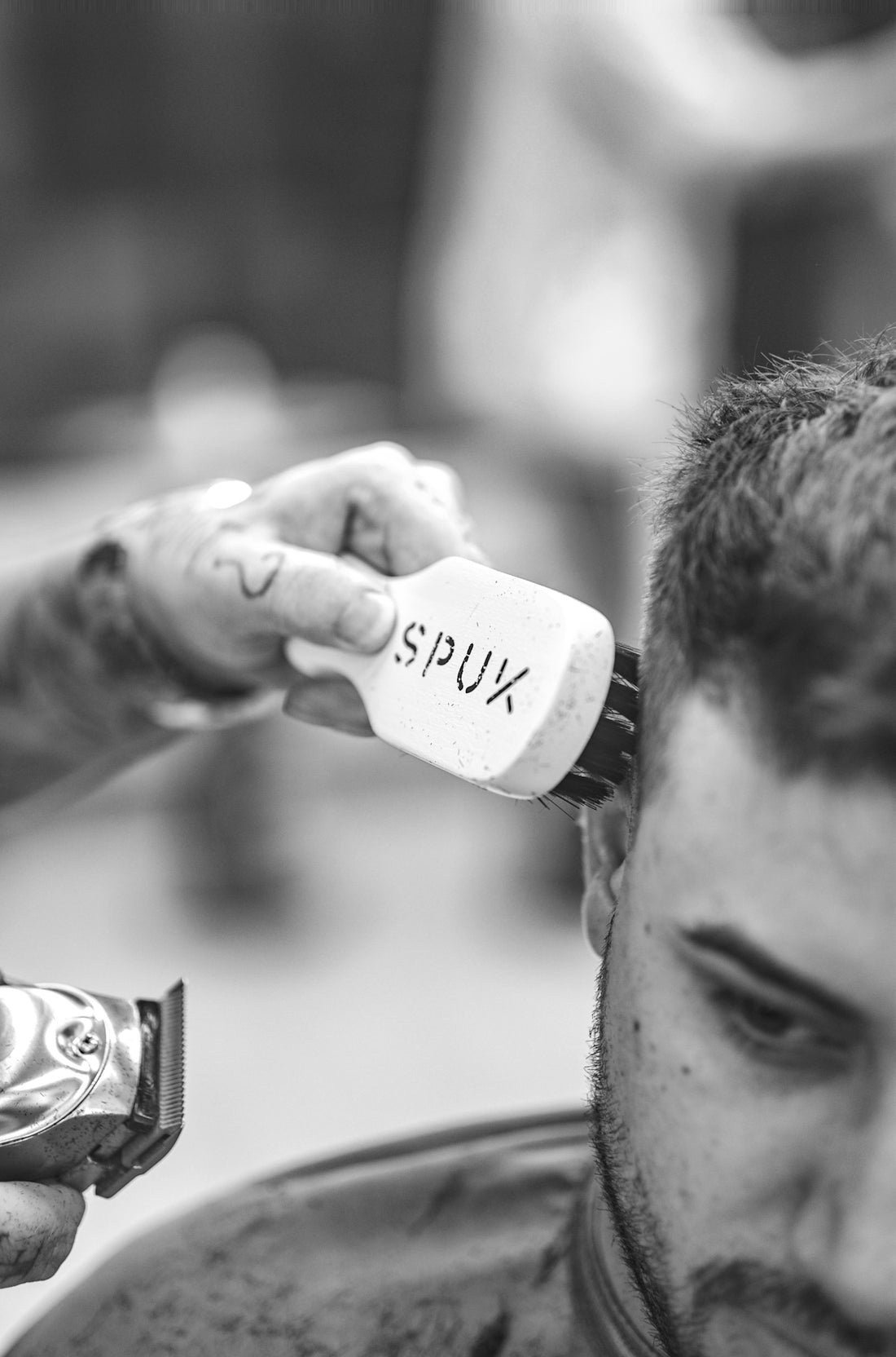 a black and white photo of a man getting his hair cut