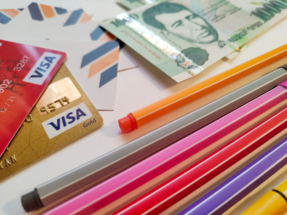 a pile of different colored pencils next to a credit card