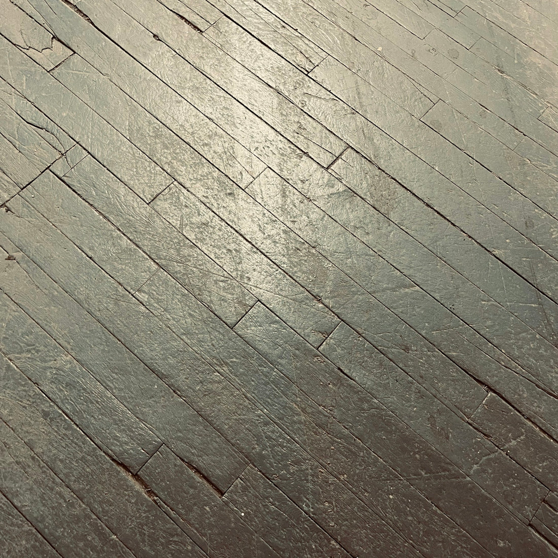 a person riding a skateboard on top of a wooden floor