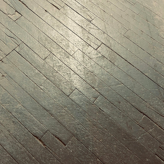 a person riding a skateboard on top of a wooden floor