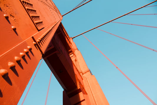 a close up of the top of a bridge against a blue sky