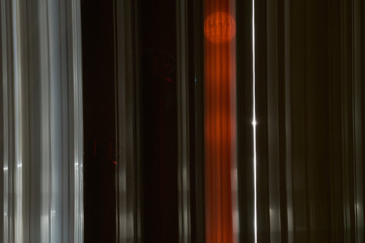 a red clock sitting on the side of a tall building