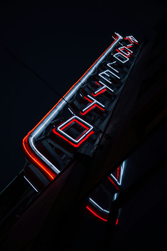 A neon sign that is on the side of a building