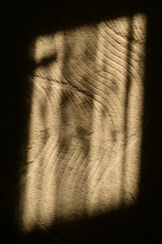 Shadow of a window on a textured wood.