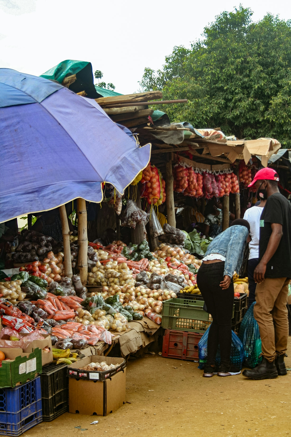 People shop for produce at an outdoor market.